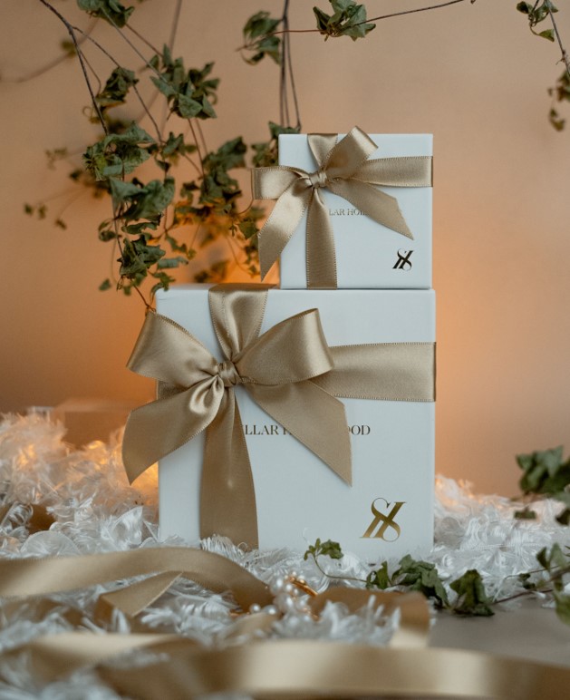 White gift boxes with beige ribbons and decorative plants